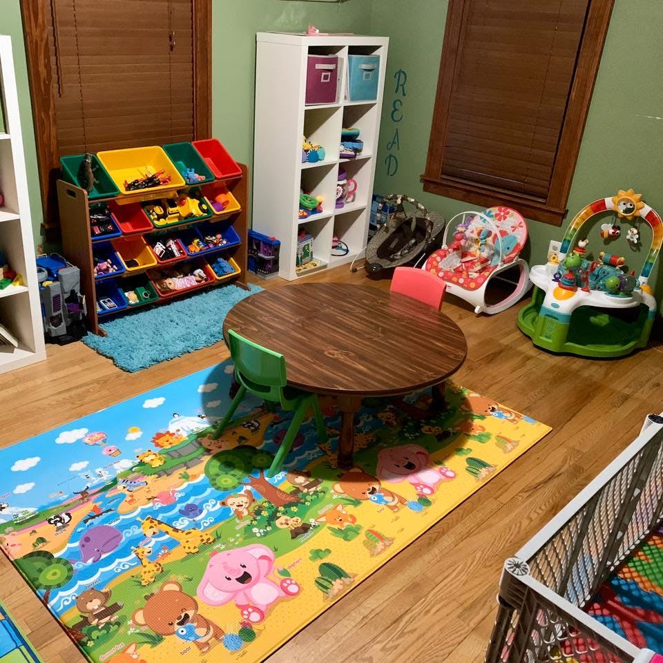 Children's play area with a small table and chairs, toy storage, and playmat