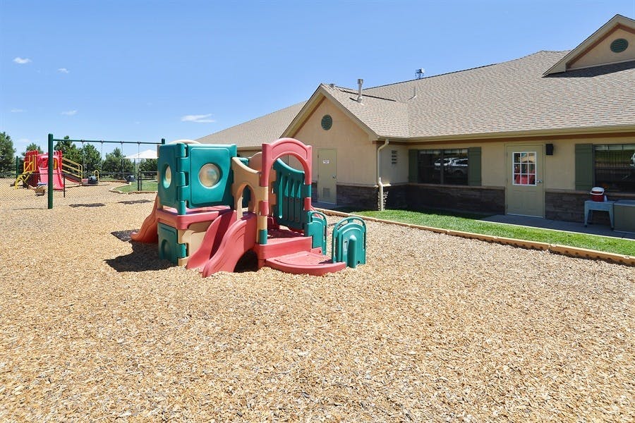 Playground with a colorful play structure and wood chips on the ground