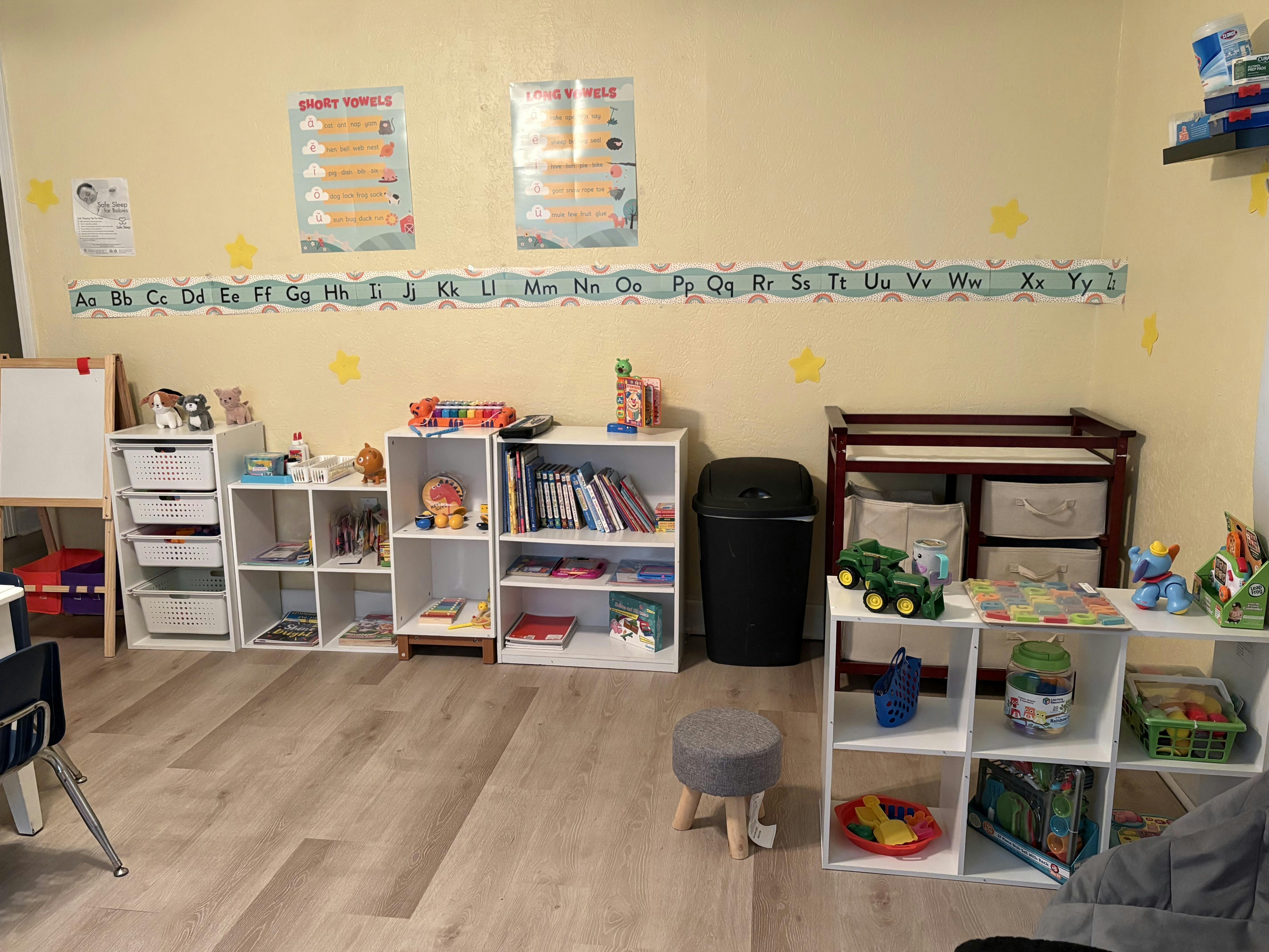 Classroom with shelves of books and toys, changing table, and whiteboard