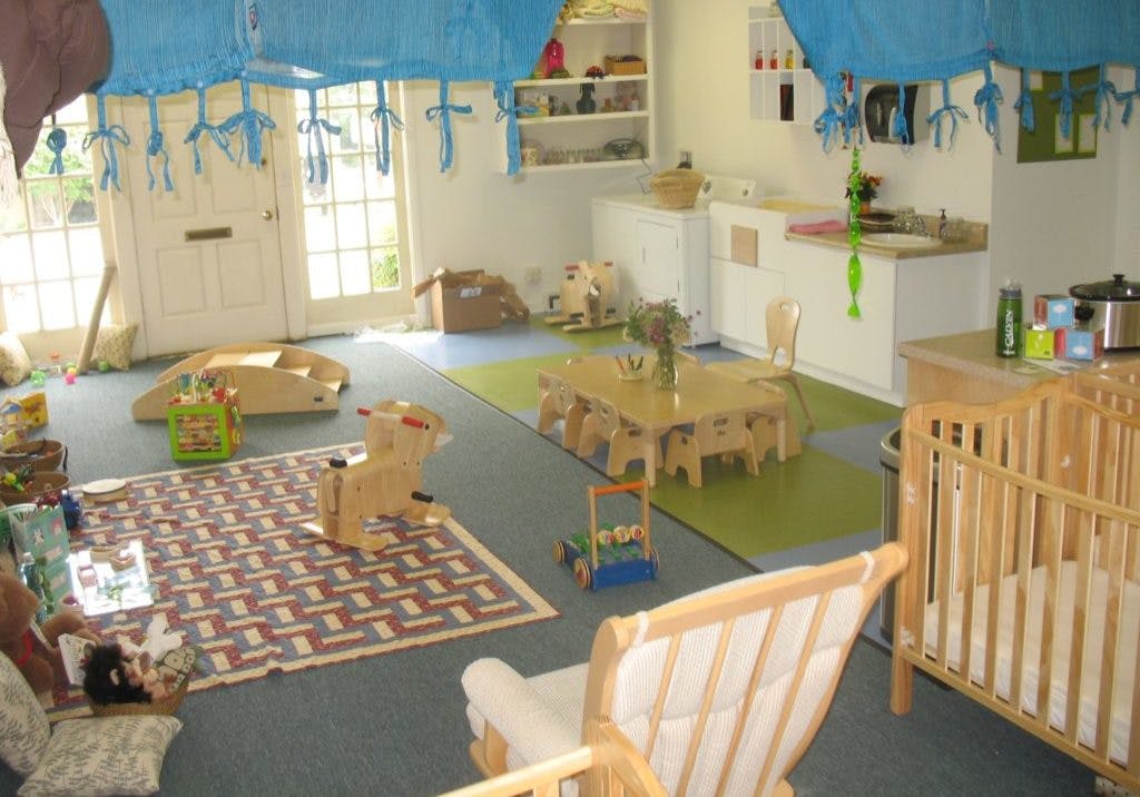 Playroom with crib, small tables, and toys