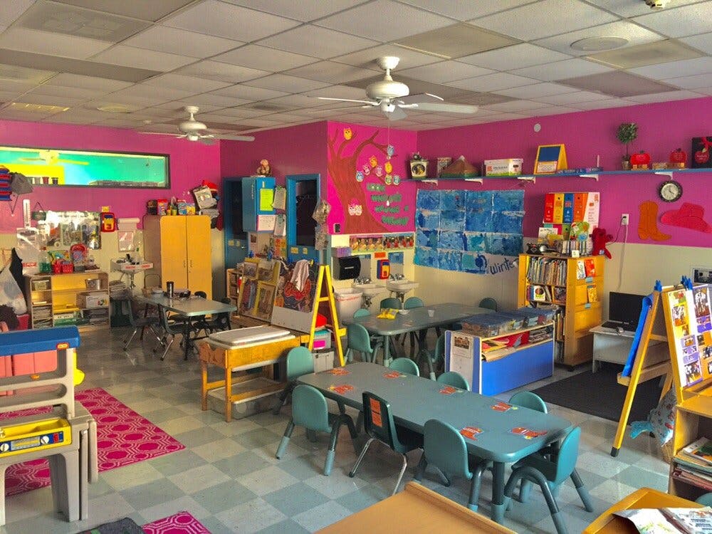 Classroom with small tables and chairs, colorful walls, and learning materials