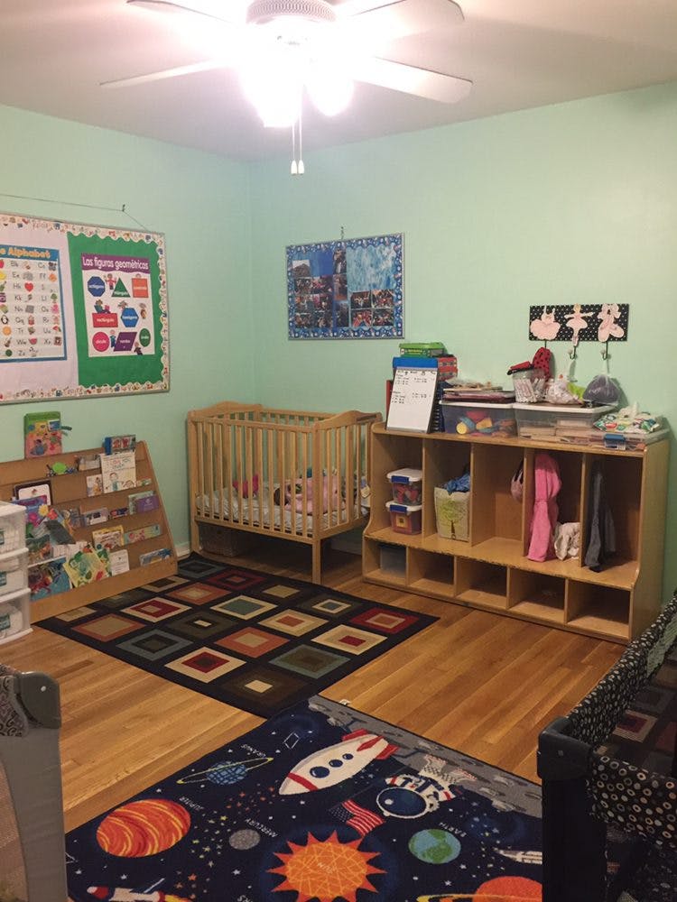A room with cribs, shelves, and colorful rugs