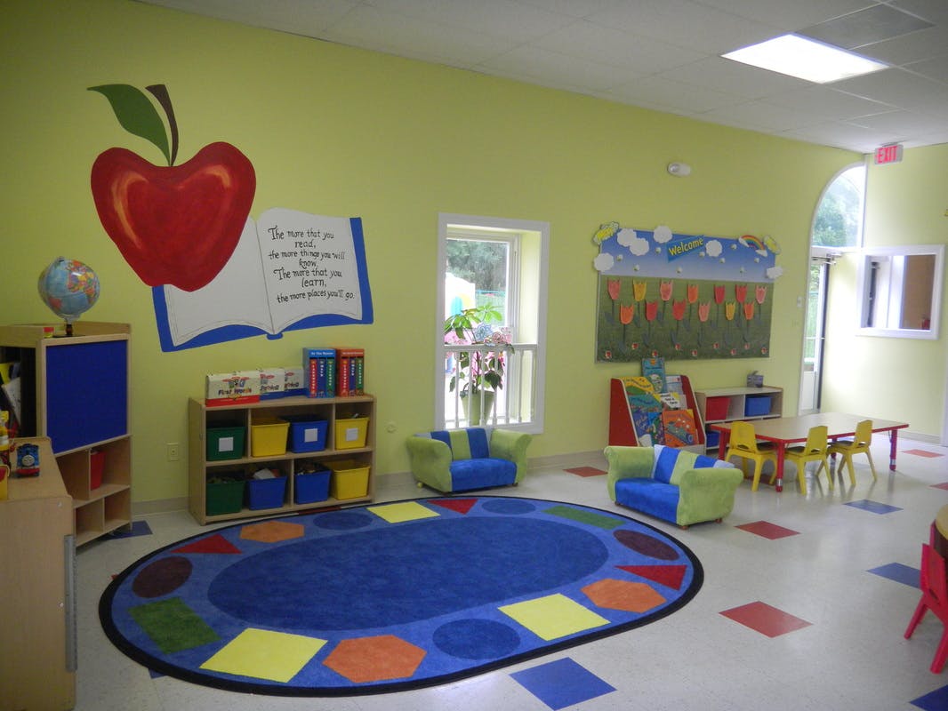 Classroom with a colorful rug, small chairs, and wall decorations