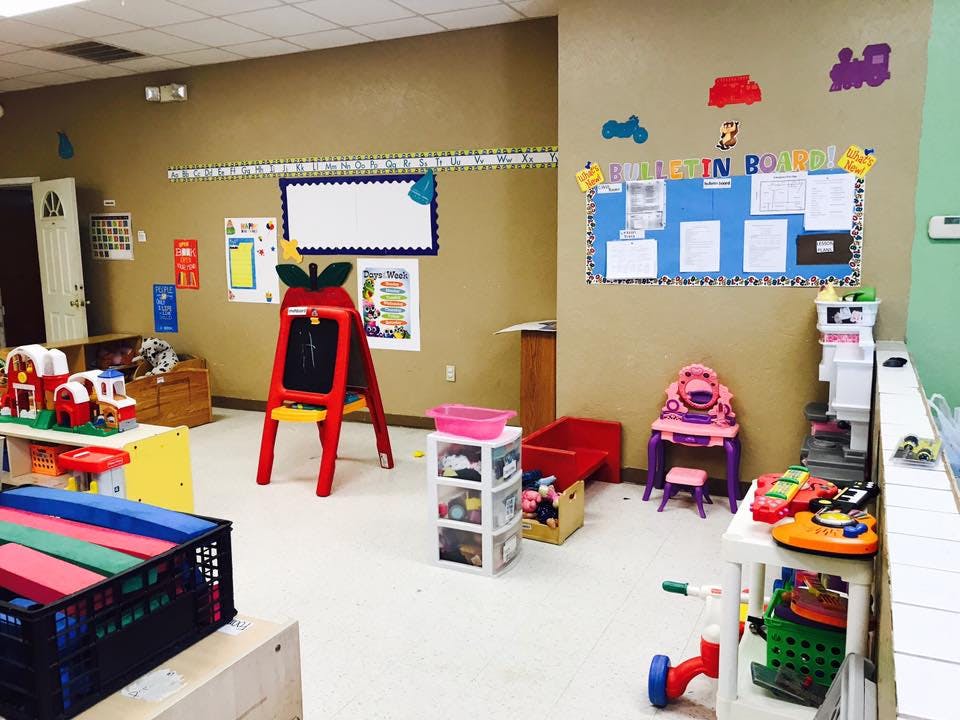 Playroom with toys, easel, and bulletin board