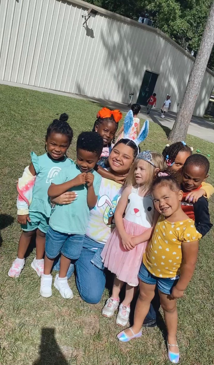 Adult person kneeling with a group of children