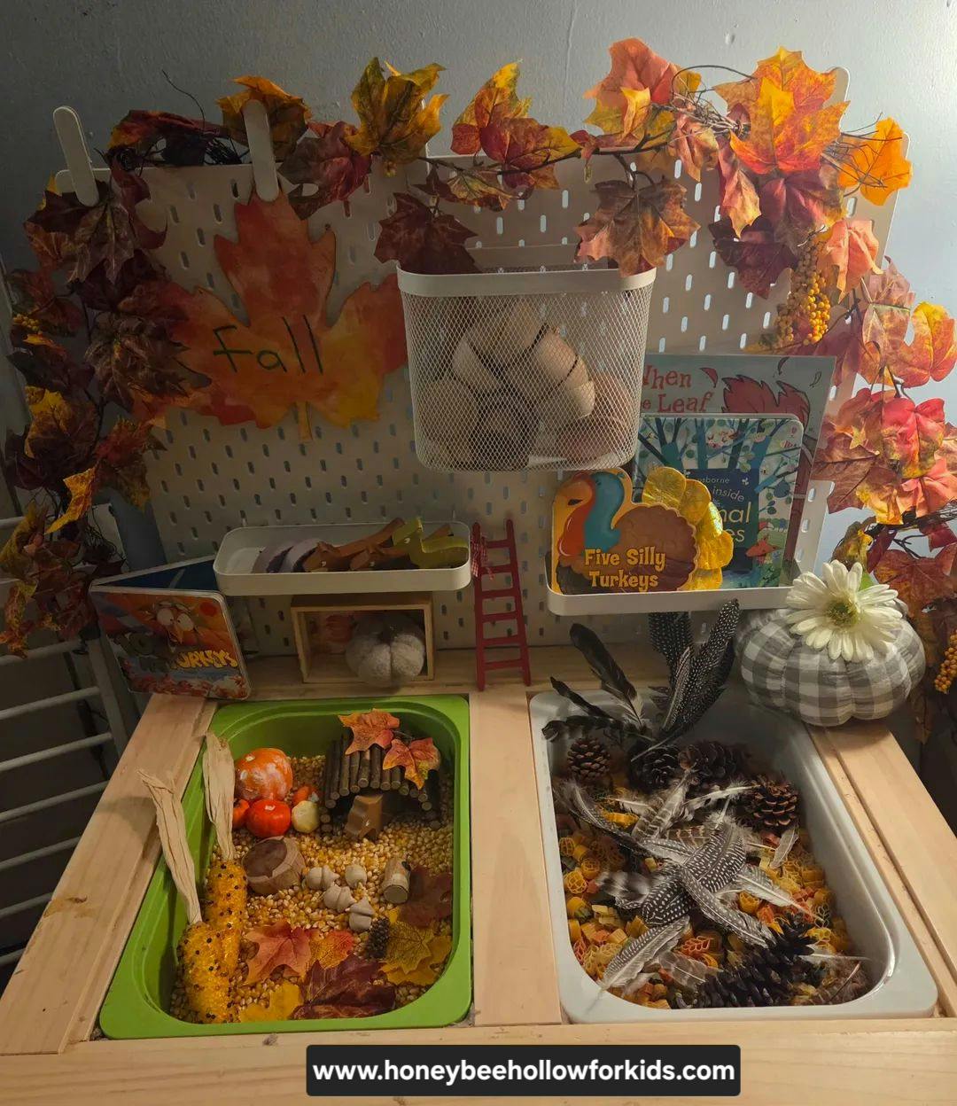 Fall themed sensory bin with autumn leaves, corn, feathers, and toy turkeys