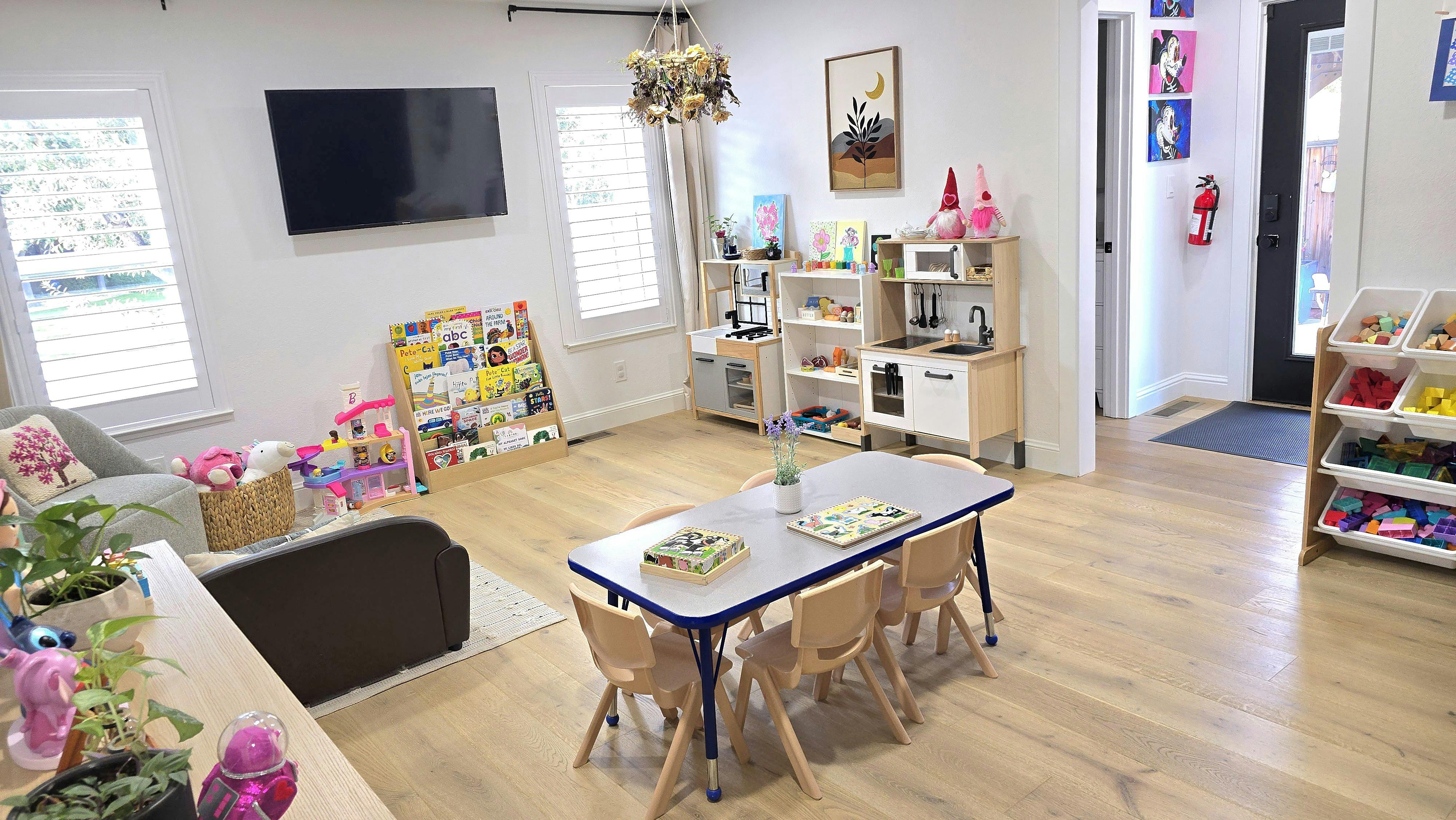 Children's playroom with play kitchen, book display, and small table with chairs