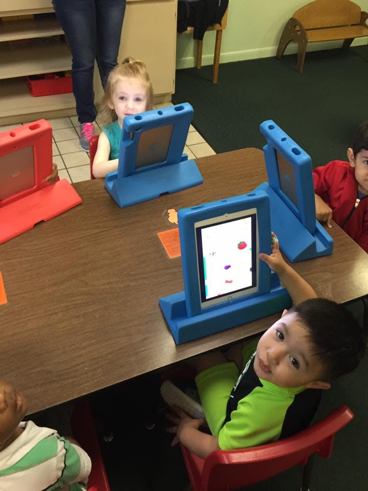 Children at a table with tablets in-case tablets