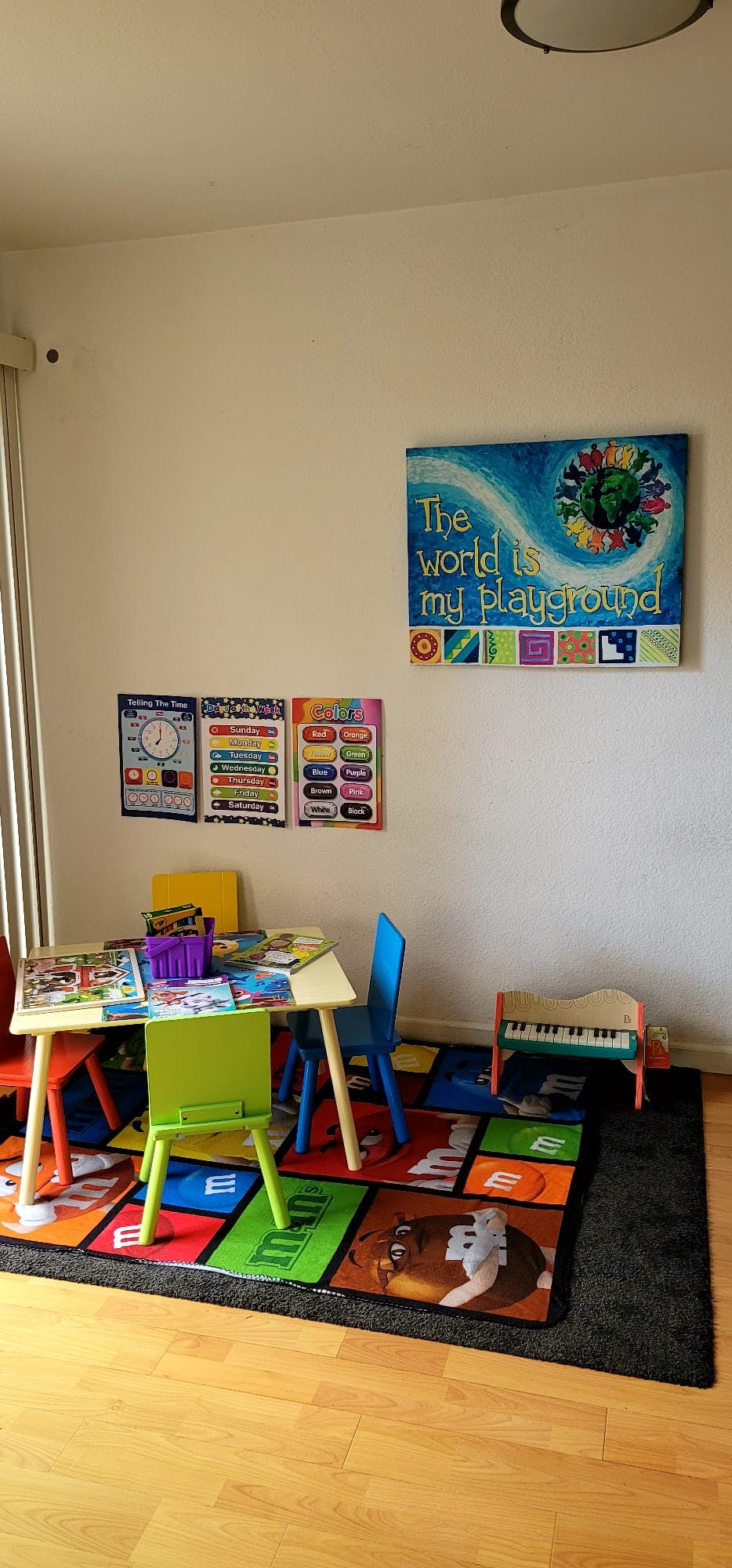 Children's play area with a small table, chairs, and a colorful rug