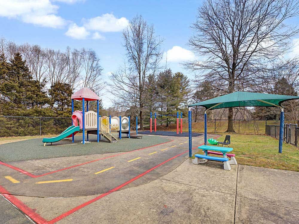 Outdoor playground with colorful slide structure and a covered picnic area