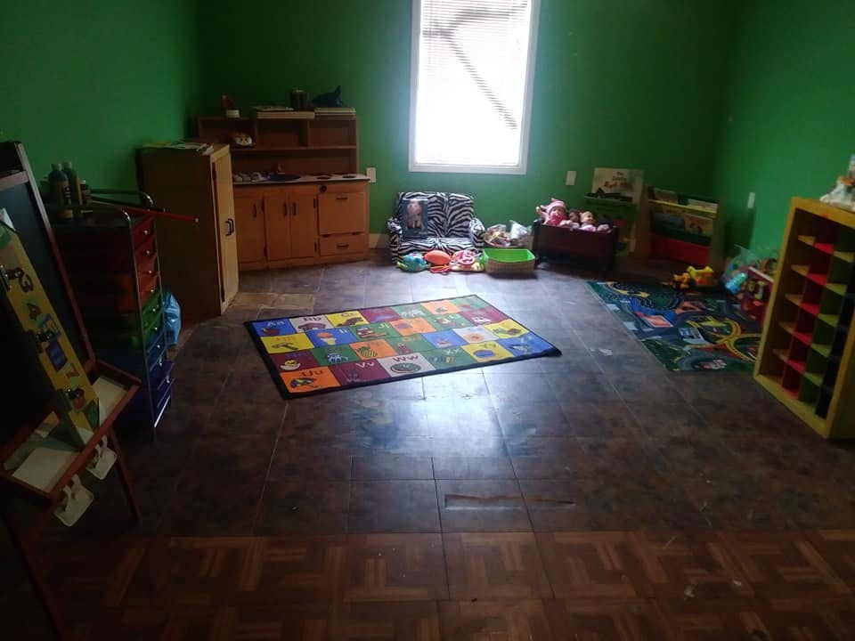 Playroom with green walls, a colorful rug, and various toys