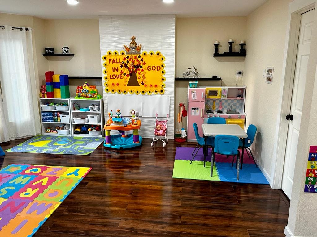 Playroom with various toys, play kitchen, and small table with chairs