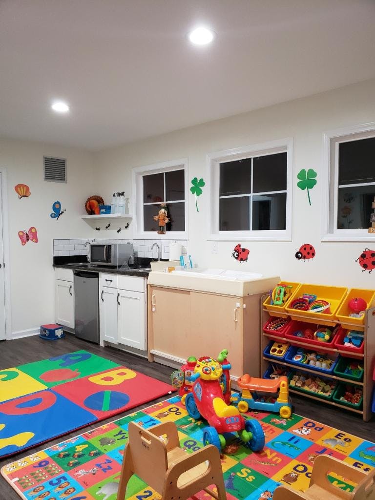 Playroom with colorful floor mats, toys, and a changing station
