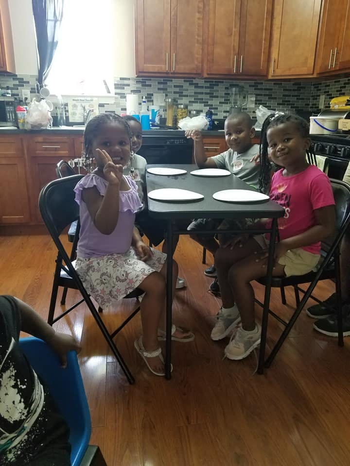 Children sitting at a table with plates in a kitchen