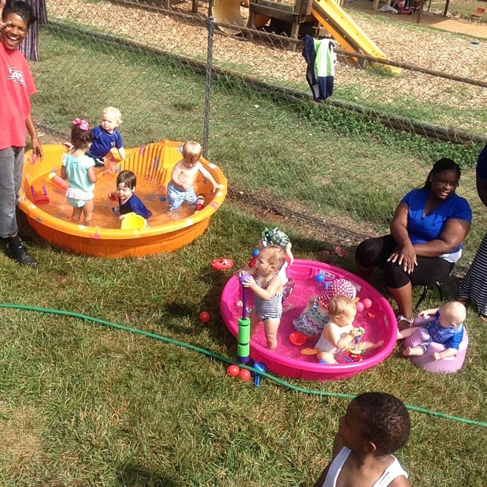 People and children playing in wading pools outdoors