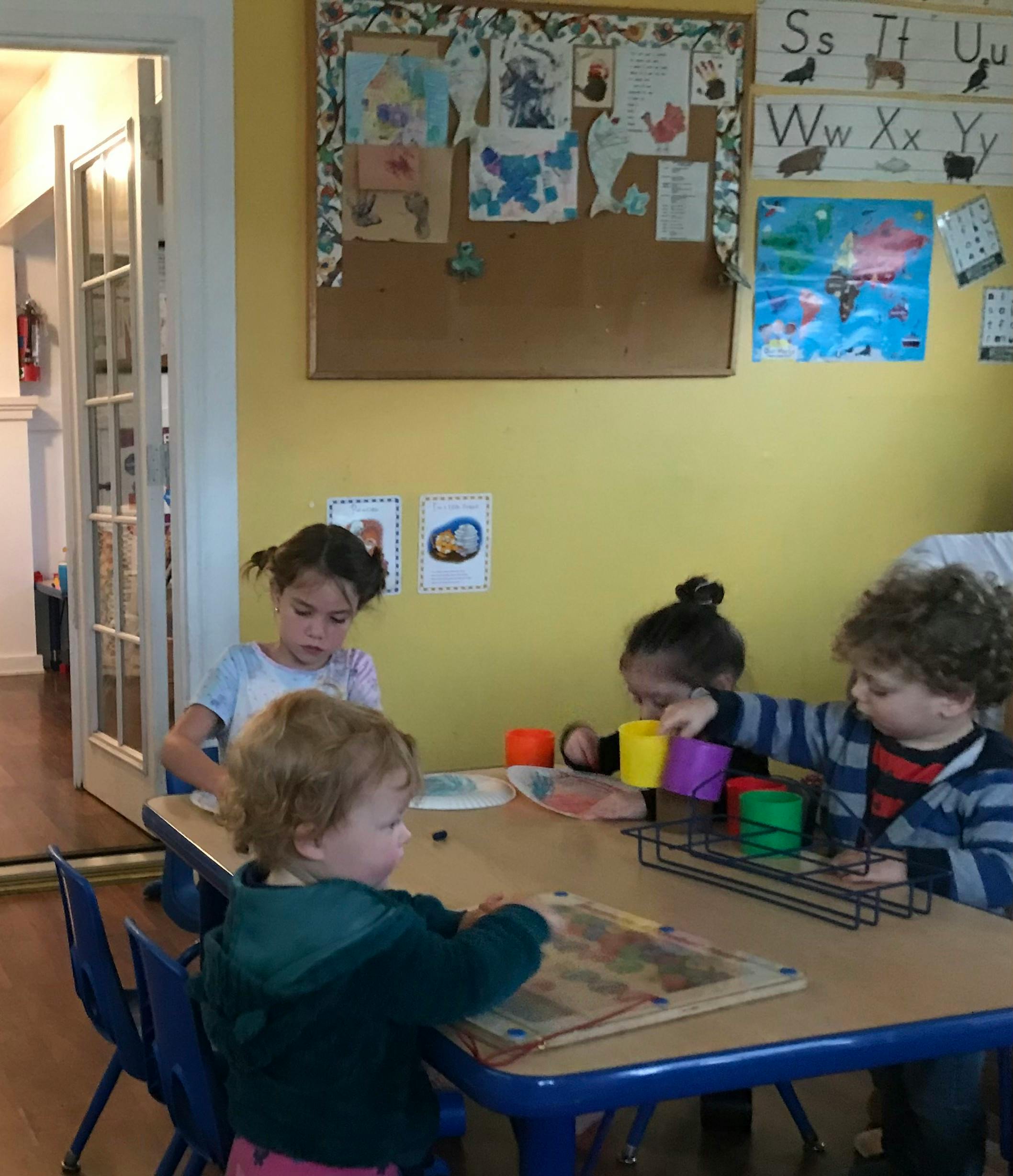 Children playing at a table in a classroom