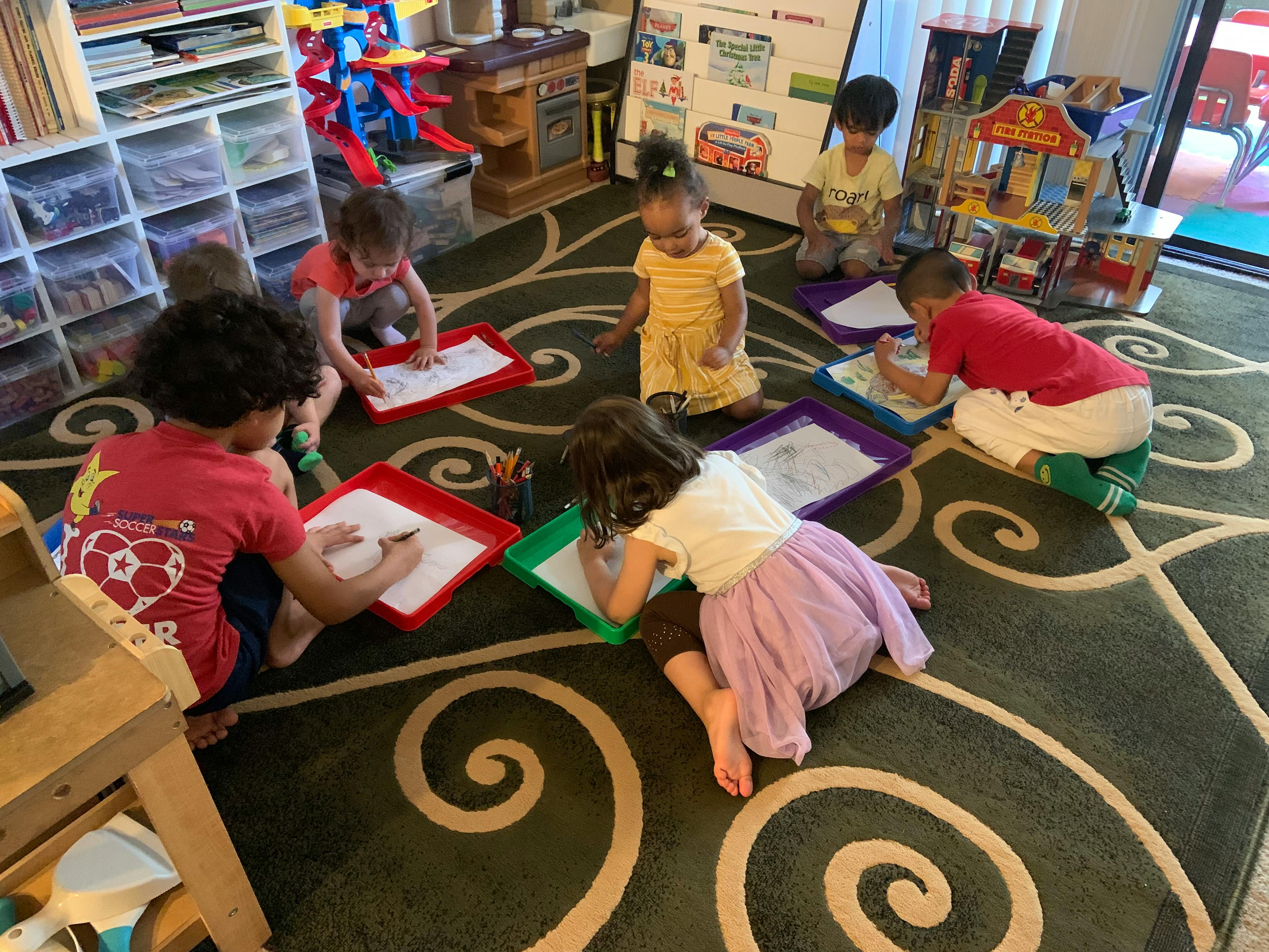 Children drawing on paper in a classroom