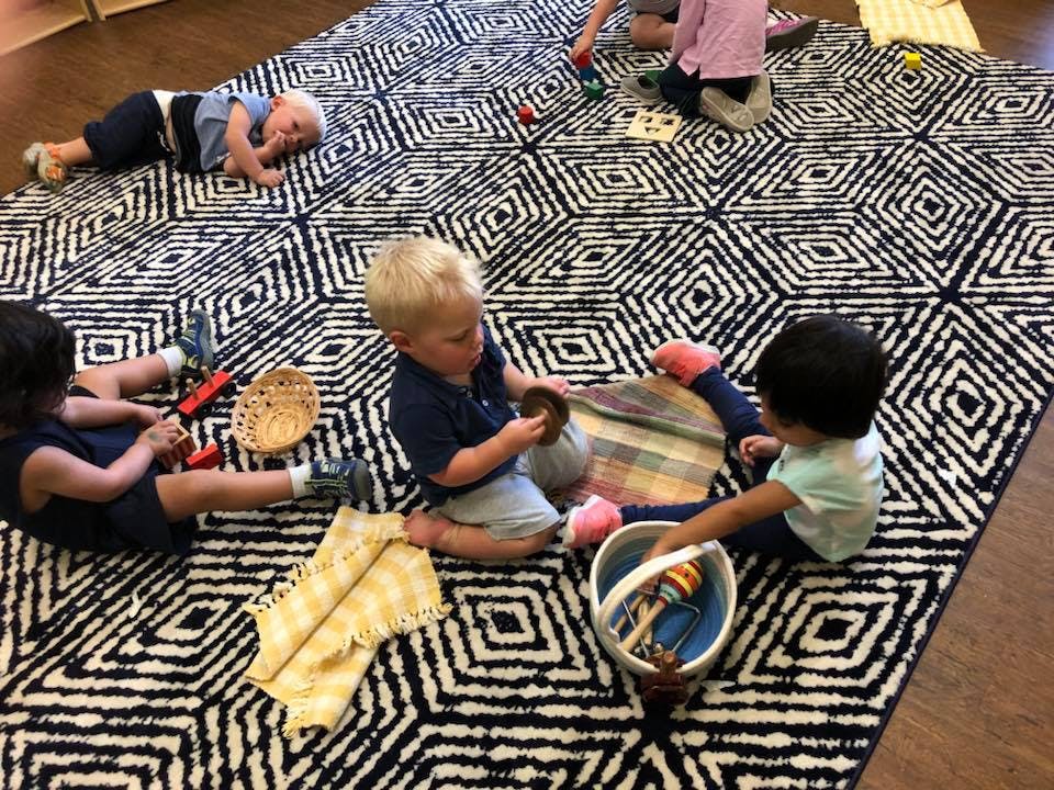 Children playing with toys on a patterned rug