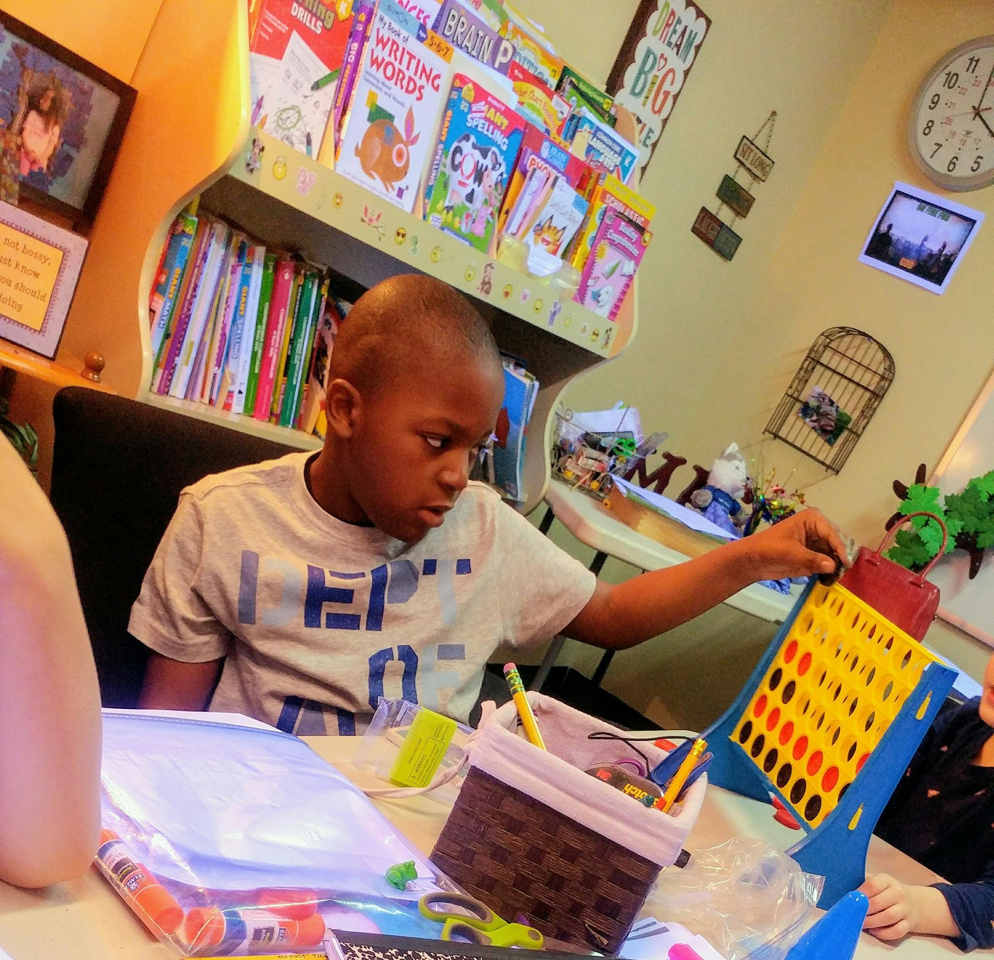 Child playing a board game at a table