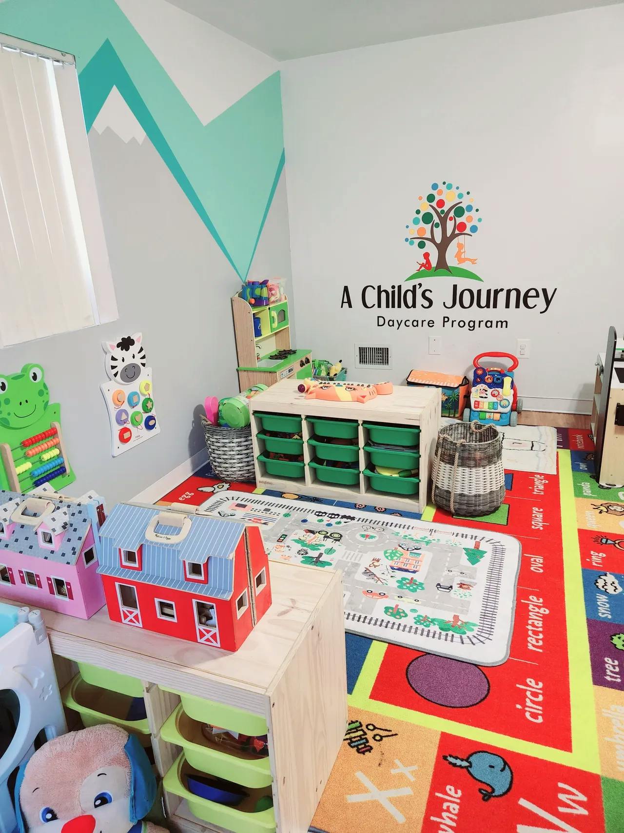 Playroom with toys, storage, and a colorful rug with letters and shapes