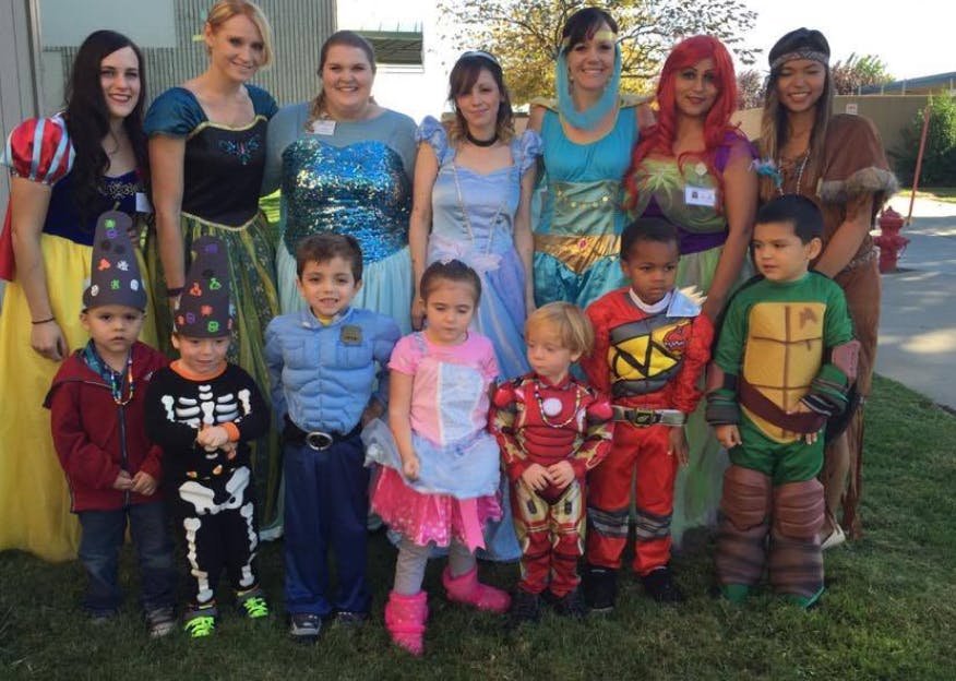 Adults and children in costumes posing outdoors