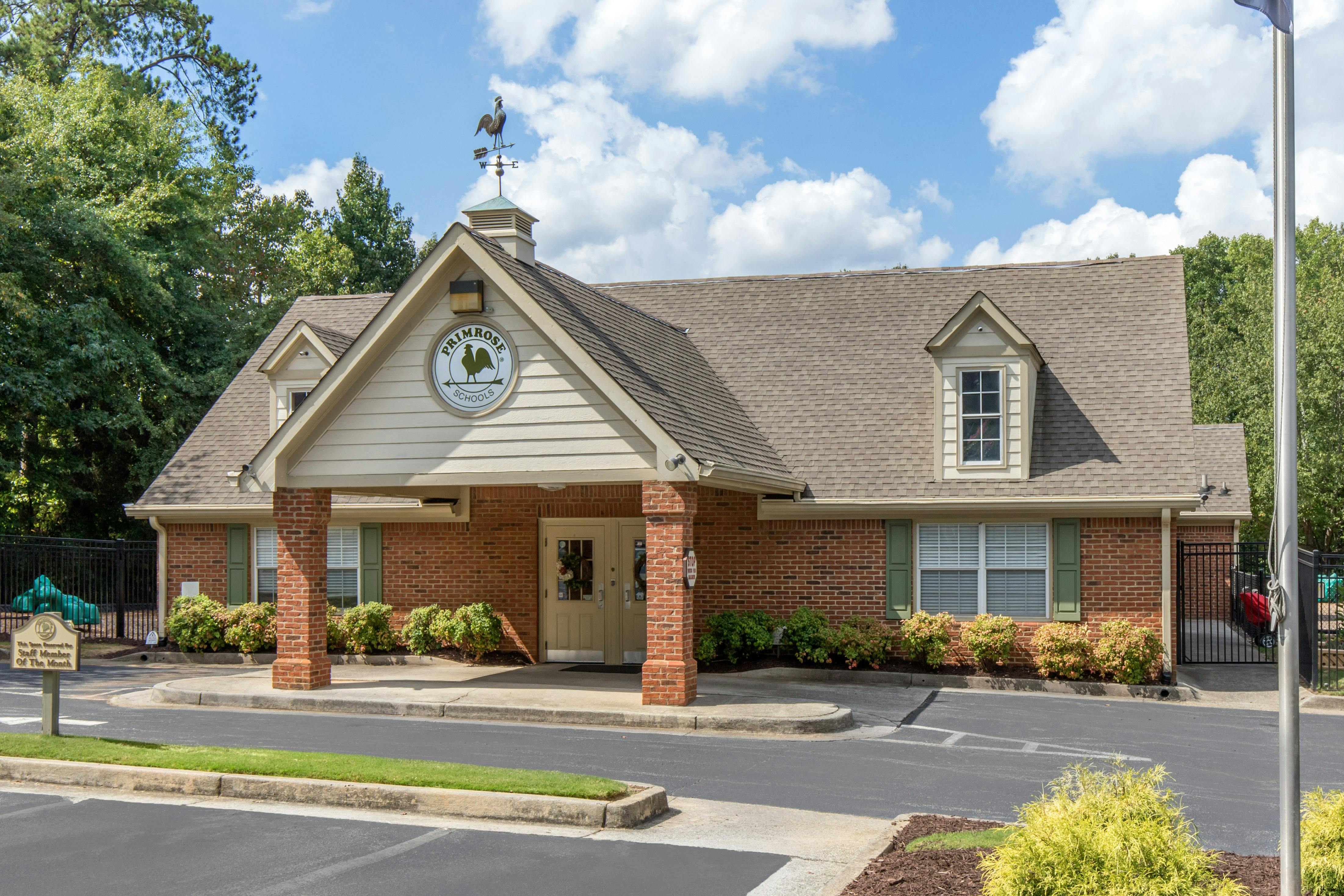Brick building with a sign that says "Primrose Schools" and a rooster weathervane