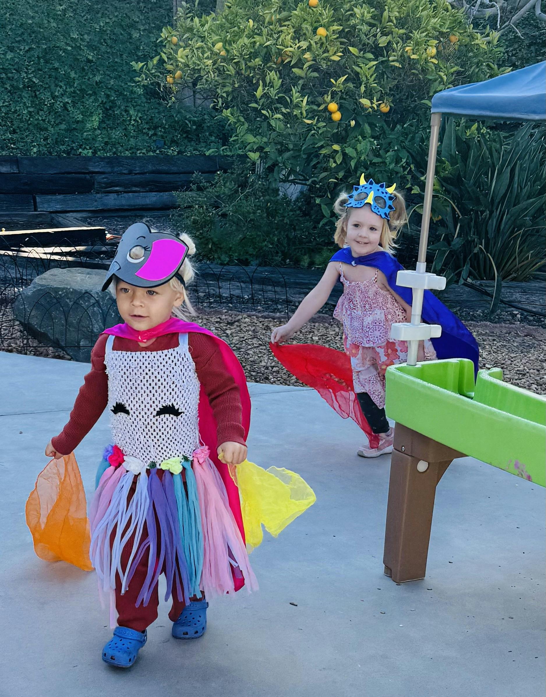 Two children in costumes playing outdoors