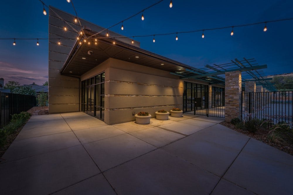 Building exterior at dusk with string lights overhead
