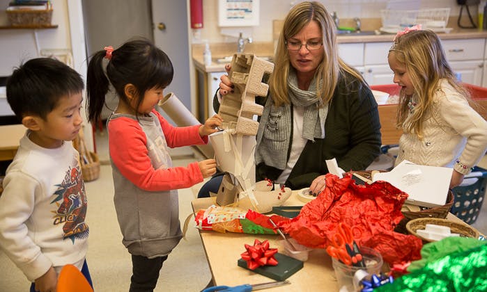 Adult and children working on a craft project at a table