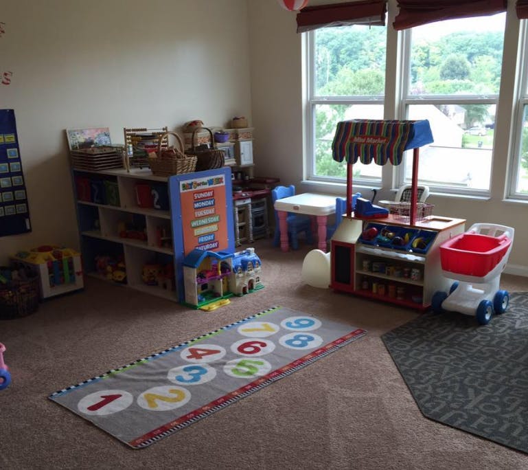 Playroom with toy kitchen, shopping cart, and number rug