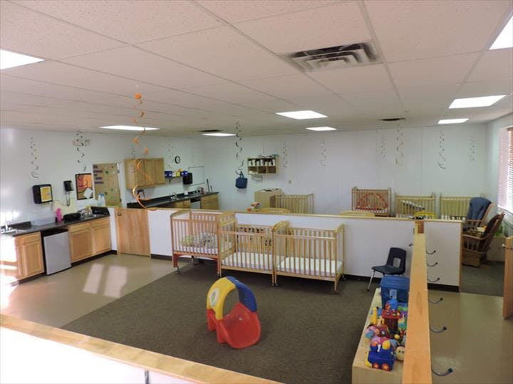 Nursery room with multiple cribs and a changing station