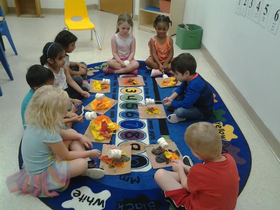 Children sitting on a rug doing an art activity