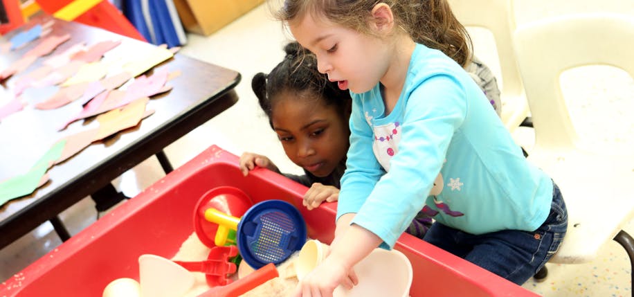 Two children playing in a sand table