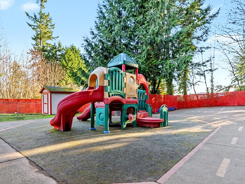 Colorful playground structure with slides on a padded surface