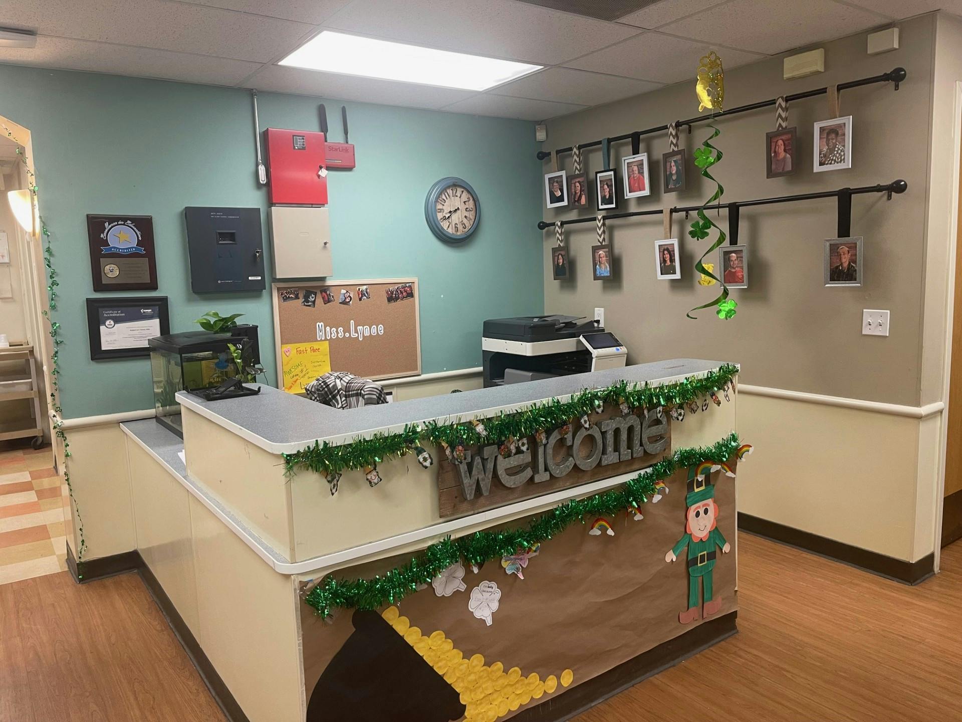 Reception desk decorated with St. Patrick's Day theme, pictures, and a \"Welcome\" sign
