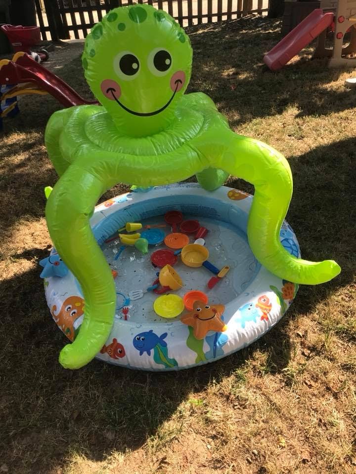 Inflatable green octopus over a small kiddie pool with toys