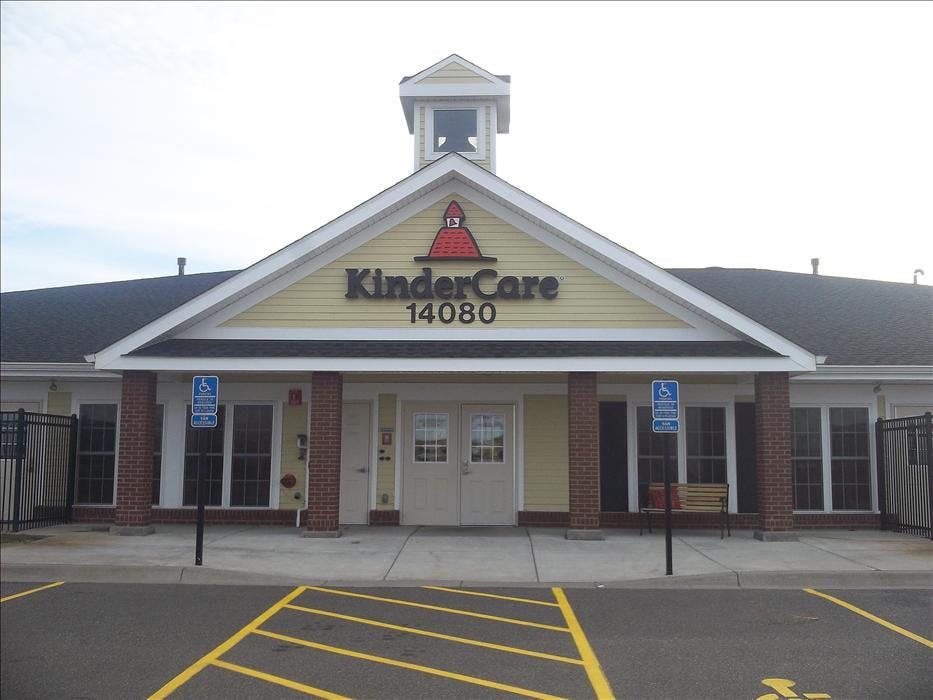 KinderCare building with yellow siding, a red roof logo, and "14080" below