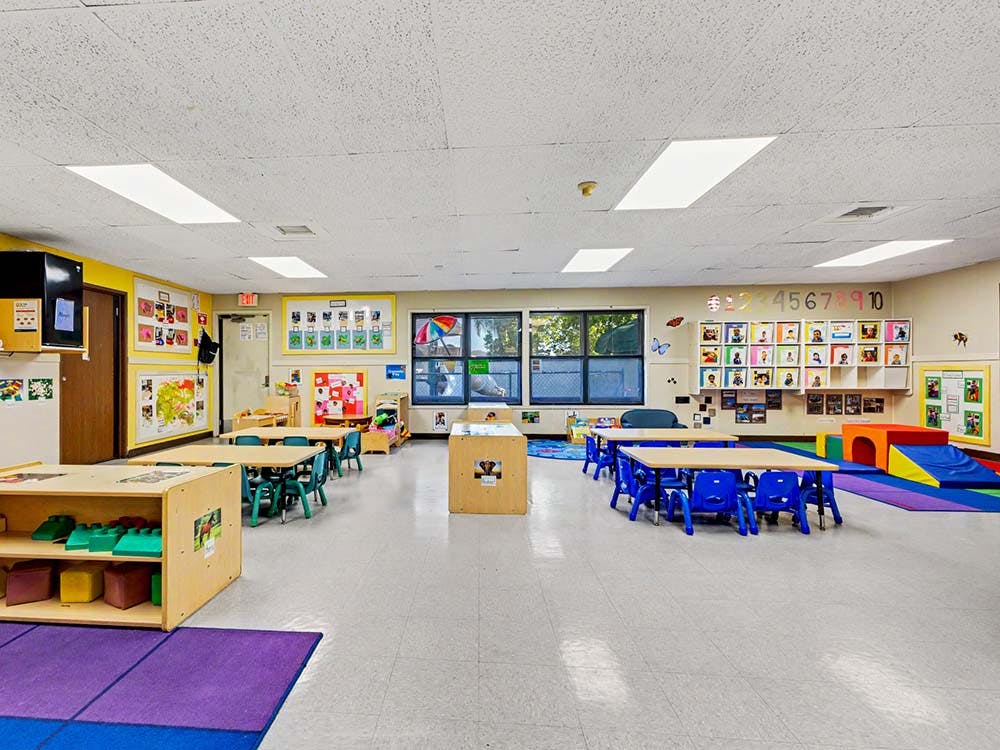 Empty colorful children's classroom with small tables and chairs