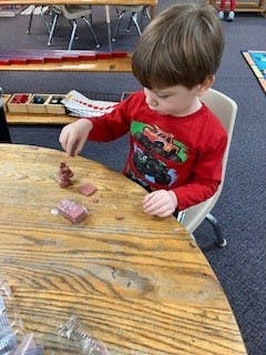 Child playing with clay at a table