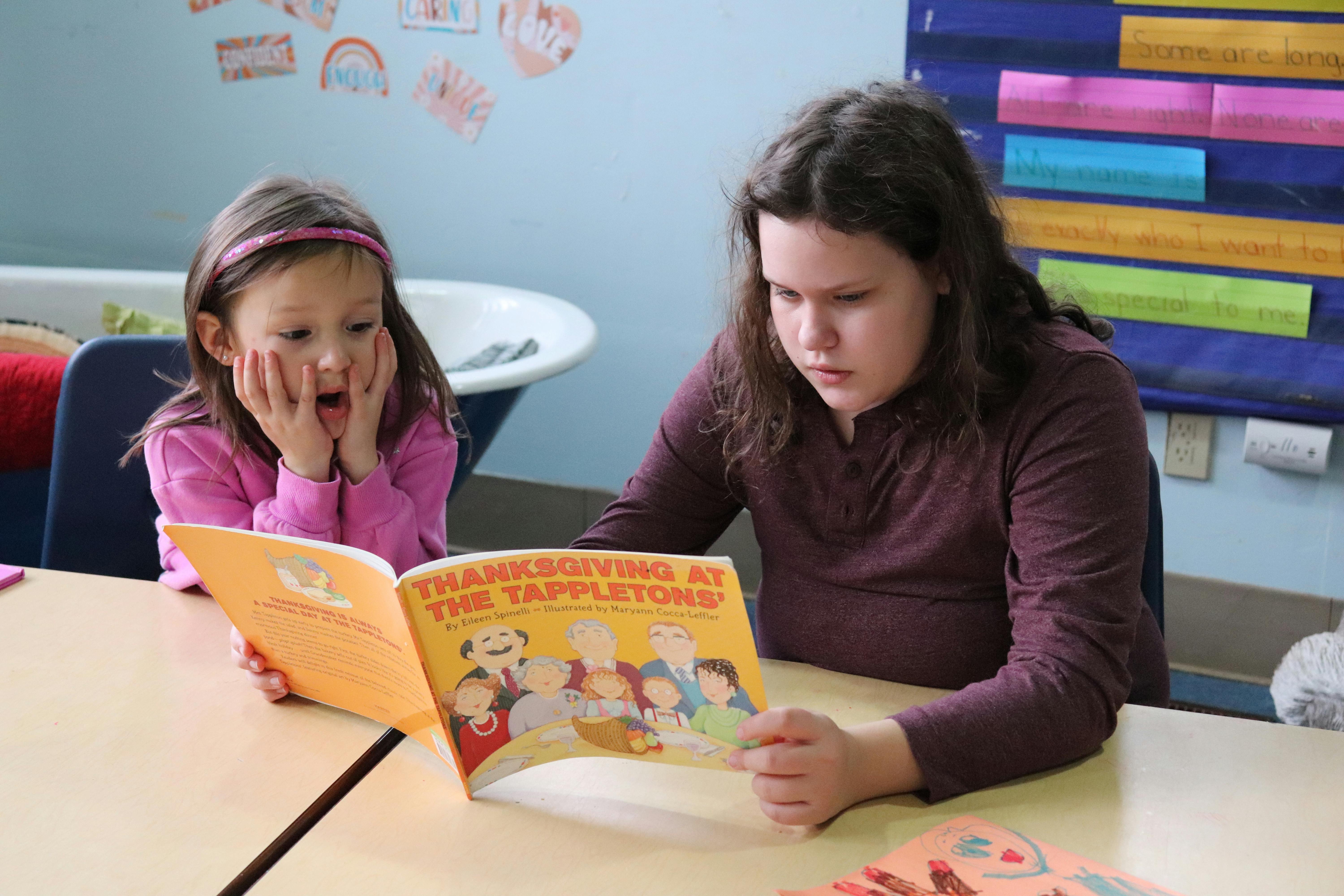 Two people reading a book titled "Thanksgiving at the Tappletons"