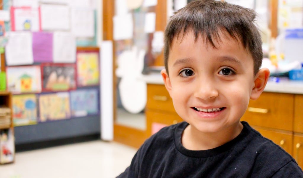 Child smiling in a classroom