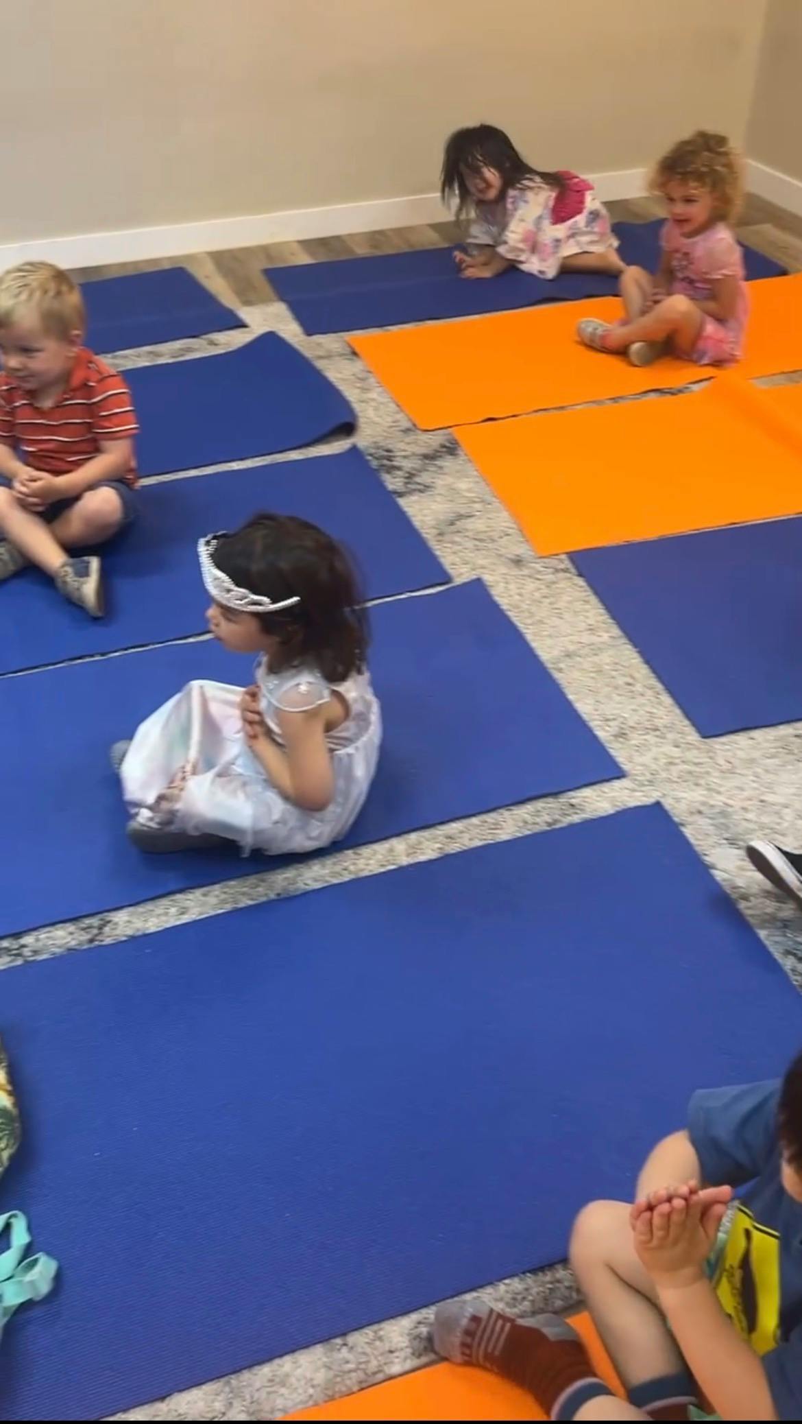 Several children sitting on yoga mats
