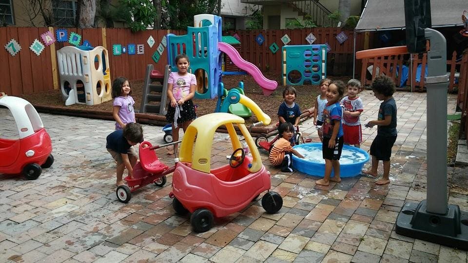 Children playing with toys and a water basin in a playground