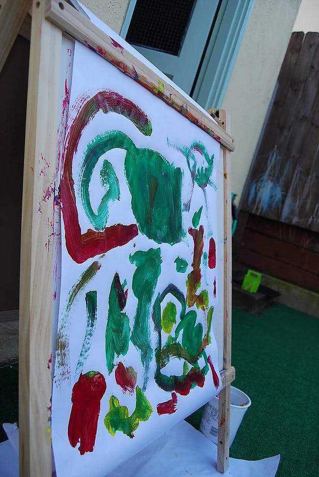 Child's painting on an easel with red and green paint