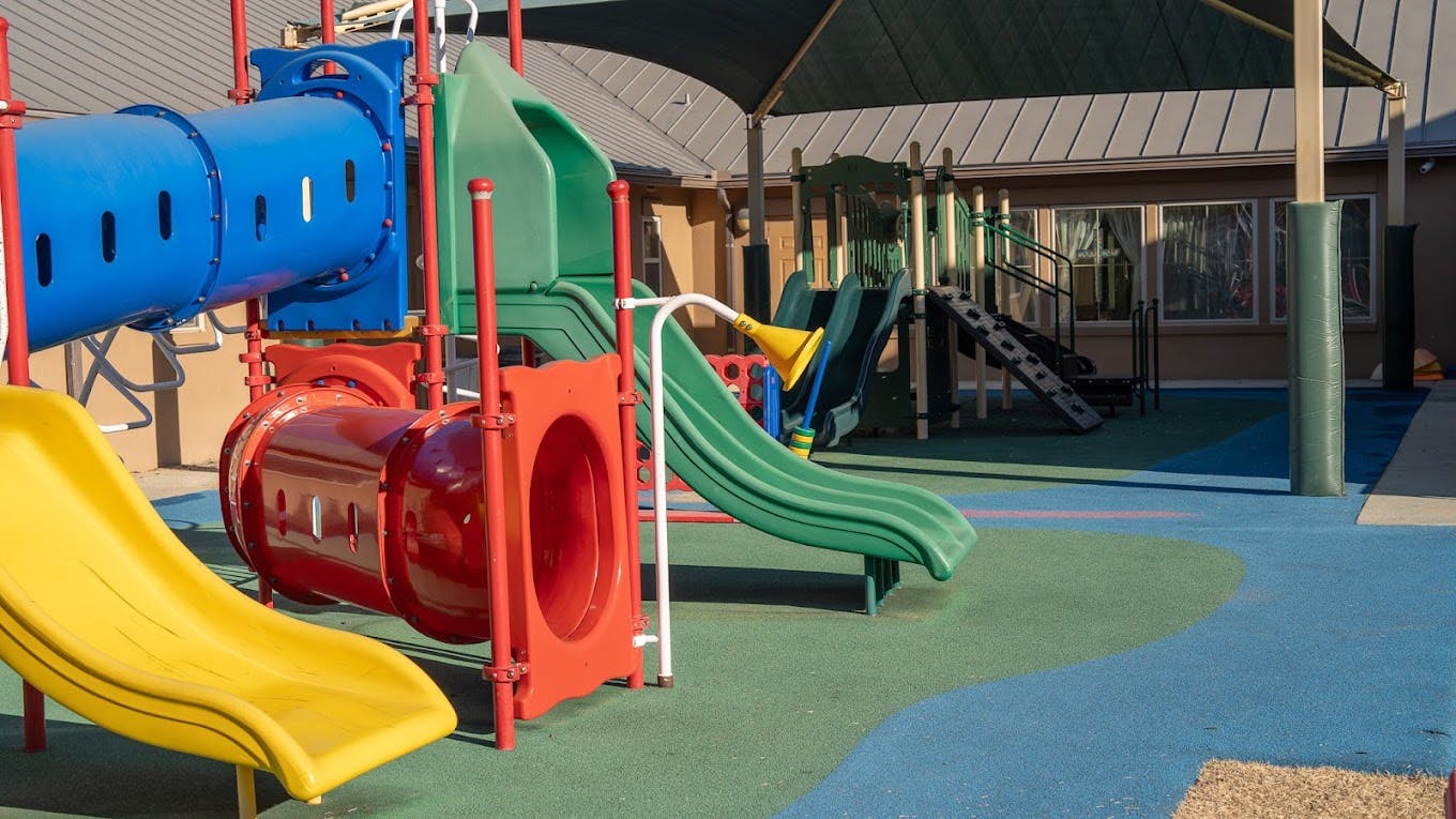 Colorful playground structure with slides and tunnels on a rubberized surface