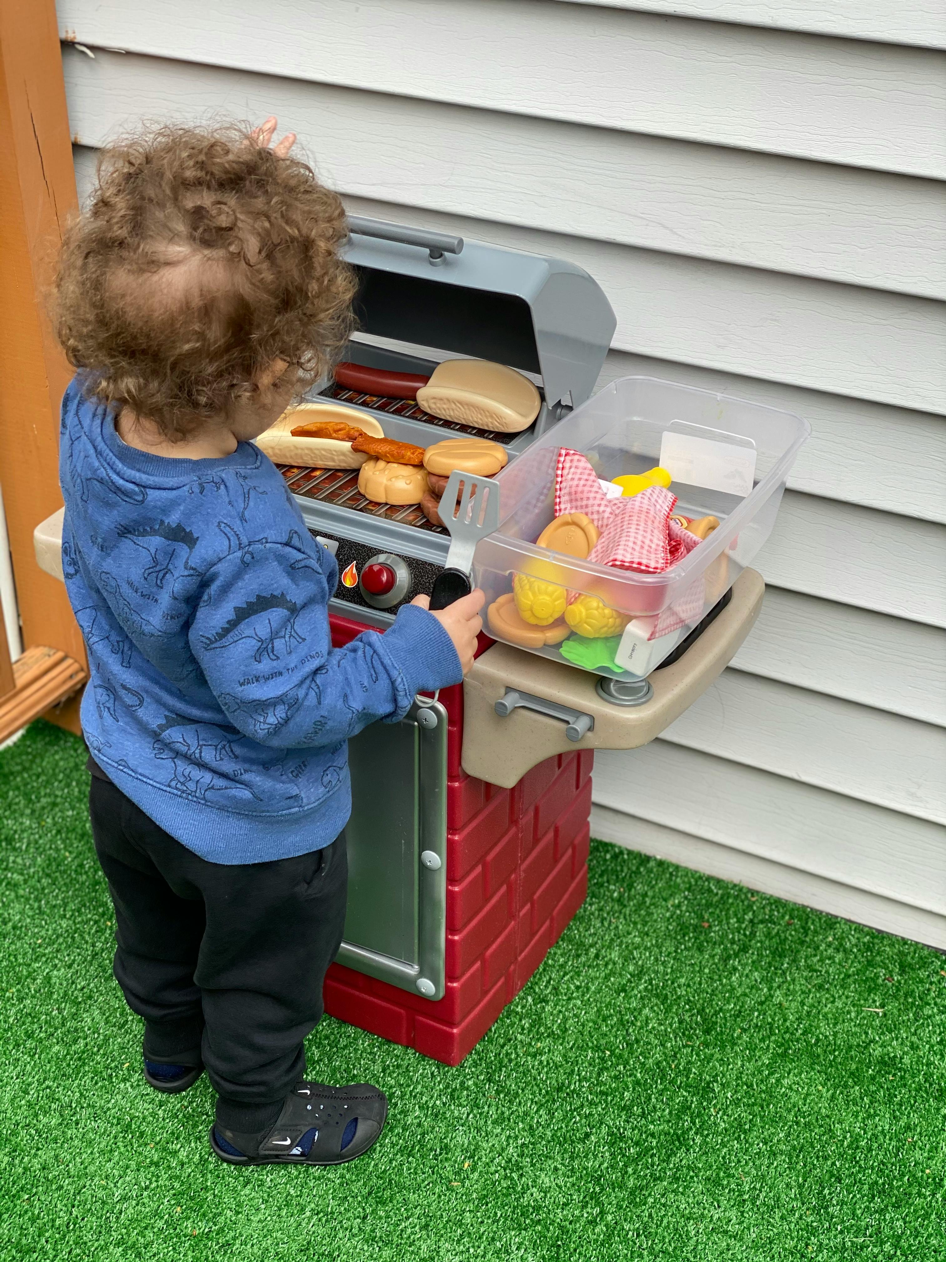 Child playing with a toy grill