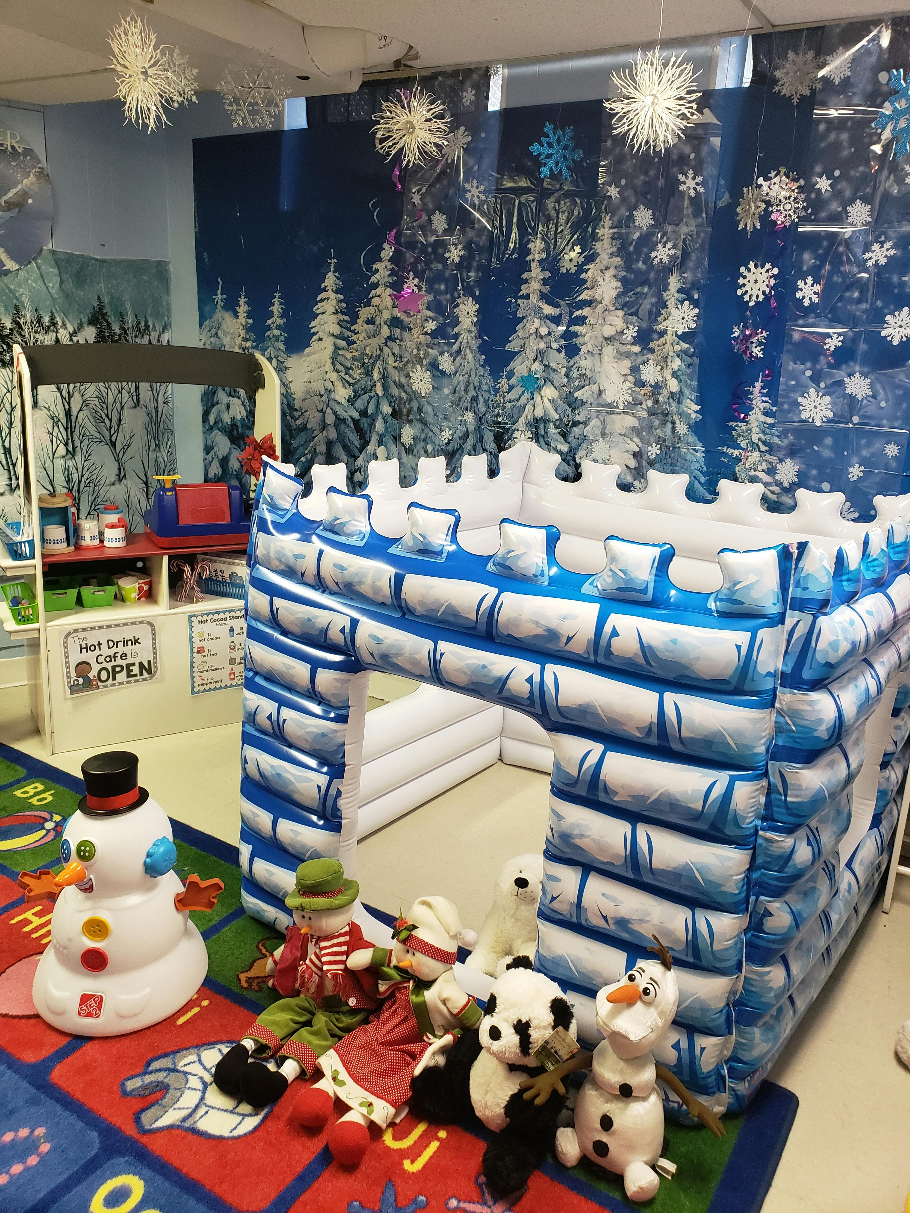 Inflatable castle with snowman and stuffed animals on a rug