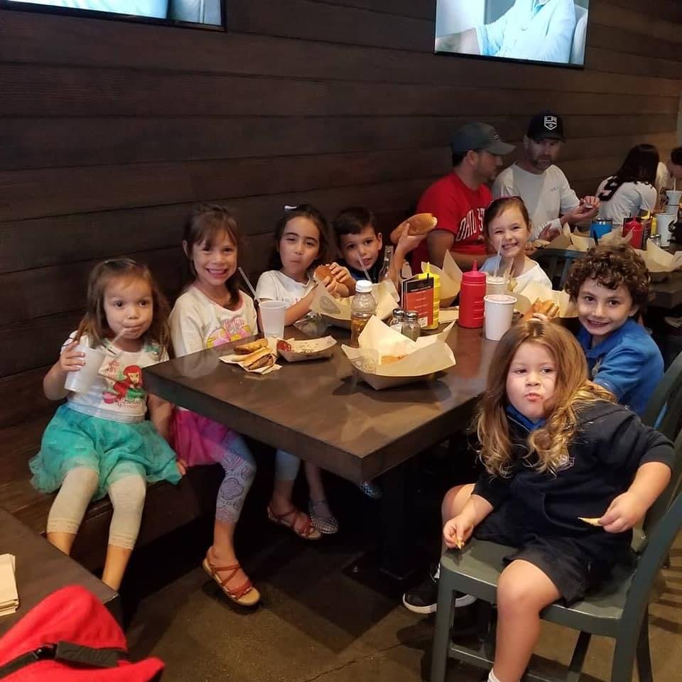Children sitting at a table with food and drinks