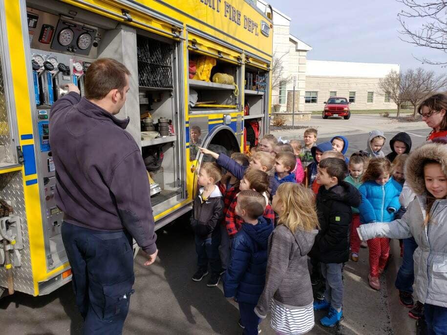Person showing children equipment on a fire truck