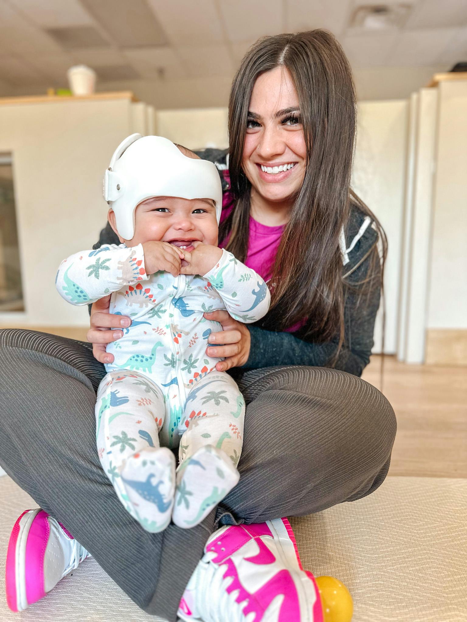 Person holding a child wearing a white helmet